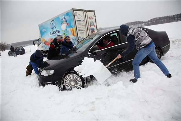 Elakadt autósok segítenek egymásnak a Vas megyei Oszkó és Csehi között 2013. január 17-én. Hófúvás miatt több dunántúli megyében elsőfokú riasztást adott ki az Országos Meteorológiai Szolgálat. A csütörtök éjfélig szóló figyelmeztető előrejelzés szerint Győr-Moson-Sopron, Vas és Zala megyében a nap folyamán erős hófúvásra is számítani lehet, amely magas hótorlaszokat emelhet a térségben.MTI Fotó: Varga György