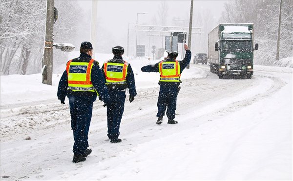 Rendőrök egy kamiont állítanak meg a szlovák - magyar határon Vámosszabadinál, ahol az erős havazás miatt forgalomkorlátozást vezettek be 2013. január 17-én. A 7,5 tonnánál nagyobb teherautókat nem engedik be az országba, a romlandó élelmiszert illetve gyógyászati eszközöket szállító kamionok kivételével. MTI Fotó: Krizsán Csaba