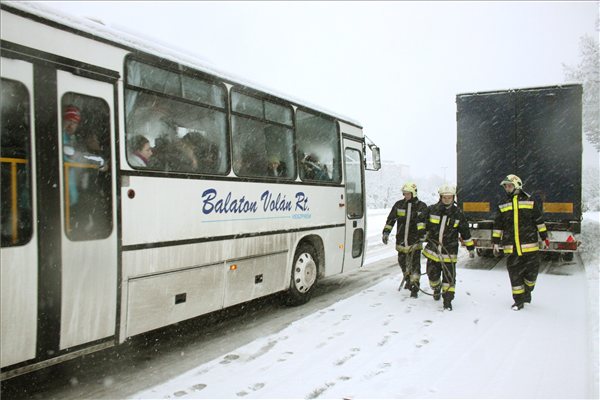 Kamionmentésre induló tűzoltók mellett halad el egy veszprémbe tartó autóbusz a 8-as számú főúton 2013. január 17-én. Az este kezdődött újabb havazás miatt a veszprémi körgyűrű több szakasza járhatatlan az elakadt kamionok miatt. A nagymennyiségű hó a városban is megneheziti a közlekedést.MTI Fotó: Nagy Lajos