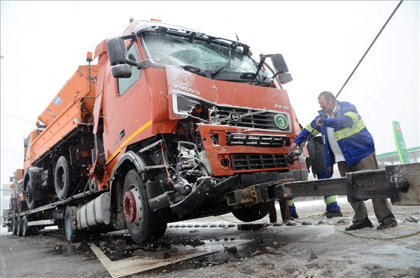 Autómentő készül elvontatni a balesetet okozó kamiont Szolnok határában, a 4-es főúton lévő körforgalomnál 2013. január 23-án. A hókotrót és sószóró munkagépet szállító román rendszámú kamion az előtte haladó járművel ütközött.MTI Fotó: Mészáros János