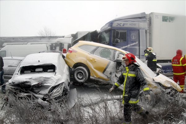 Tűzoltók és mentők az M7-es autópályán, Szabadbattyán közelében, ahol tömeges baleset történt 2013. március 14-én. Több ember beszorult a roncsokba, őket a tűzoltók és a mentők szabadították ki. MTI Fotó: Koppán Viktor