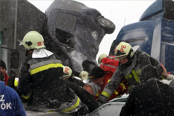 Tűzoltók és mentők kiszabadítanak egy beszorult embert az M7-es autópályán, Szabadbattyán közelében, ahol tömeges baleset történt 2013. március 14-én. MTI Fotó: Koppán Viktor