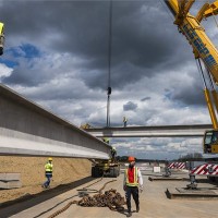 Egy 44,8 m hosszú, 56,5 tonnás hídgerendát készítenek elő helyére emelése előtt az épülő M3-as autópályán, Pusztadobosnál 2014. április 15-én. Összesen kilenc, Dunaújvárosban készült gerendát építenek be az autópályán átívelő felüljáróba a Szabolcs-Szatmár-Bereg megyei település határában. MTI Fotó: Balázs Attila