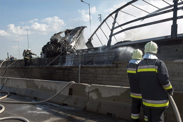 Tűzoltók dolgoznak Budapest XXII. kerületében, az M0-s körgyűrű a 6-os út kihajtója közelében, ahol egy kamion az elválasztó betonfalnak csapódott, majd kigyulladt 2014. június 11-én. A Szeged felé vezető oldalon történt balesetben egy személy könnyebben sérült meg. MTI Fotó: Lakatos Péter