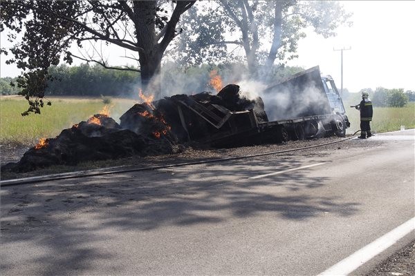 Tűzoltó oltja egy szalmabálákat szállító kamion rakományát az 52-es főút 15-ös kilométerénél, Kecskeméttől nem messze 2015. július 16-án. A tűzesetben senki nem sérült meg. MTI Fotó: Donka Ferenc