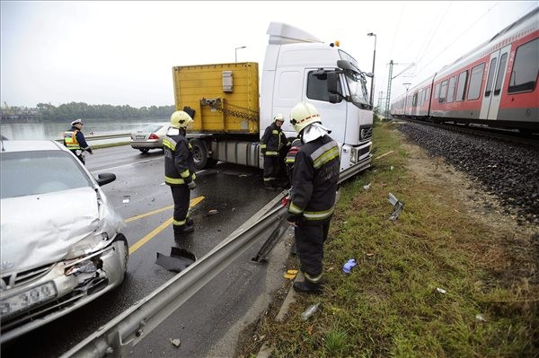 Összeroncsolódott személyautó és teherautó 2015. október 14-én a 6-os út kifelé vezető szakaszán, a Hunyadi János út után, ahol két teherautó és egy autó összeütközött. Az egyik teherautó sofőrje súlyosan megsérült és beszorult a vezetőfülkébe. Az autó vezetője könnyebb sérüléseket szenvedett. MTI Fotó: Mihádák Zoltán
