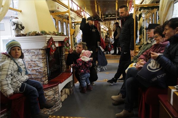 Utasok a kandallóval felszerelt, a Miskolc Városi Közlekedési Zrt. fényfüzérekkel feldíszített villamosán Miskolcon 2015. december 3-án. Az adventi villamosok január 6-ig, vízkeresztig közlekednek. MTI Fotó: Vajda János