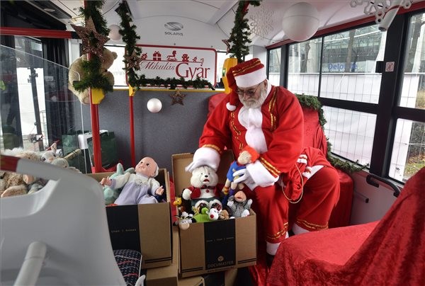 A mikulás rendezi az ajándékokat a Mikulástroli nevű járaton, Budapesten, az 56-osok terénél, a Mikulásgyár mellett 2015. december 5-én. A menetrendszerinti járat egyedi belső és külső dekorációval közlekedik, és ajándékot gyűjt rászorulóknak. MTI Fotó: Máthé Zoltán