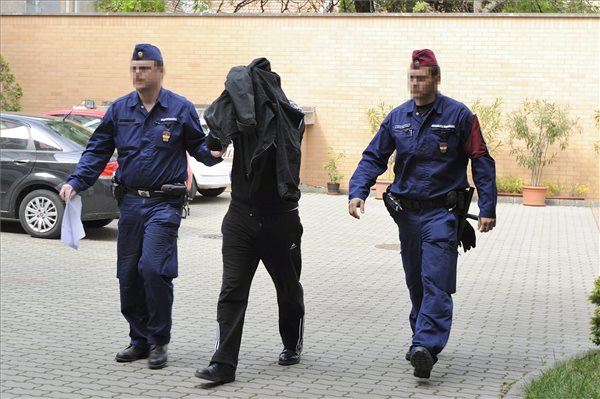  Rendőrök kísérnek egy arcát kabátjával eltakaró, korrupcióval gyanúsított gyulai határrendészt a Szegedi Törvényszék katonai tanácsának udvarán az előzetes letartóztatásról döntő ülésre 2014. április 18-án. MTI Fotó: Kelemen Zoltán Gergely